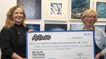 Arthead's Sonja Millis presents a $3320 cheque to Can Assist Southern Highlands President Jenny Harper, at the opening of the Blue Square Art Competition. Picture by John Swainston