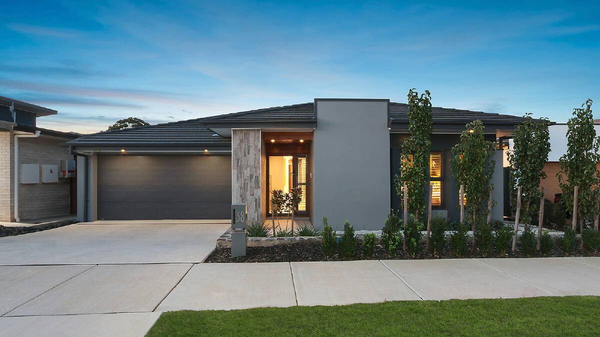 The two-tone charcoal facade of the residence contrasts elegantly with the neatly manicured front garden.