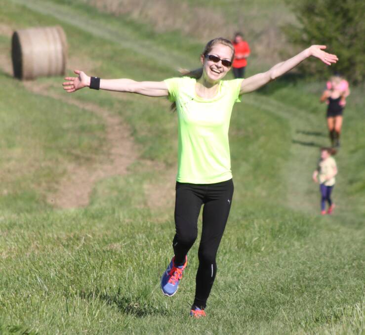 HAPPY DAYS: Joanna Belcher smiles as she runs up a hill at The Briars course during a Bowral Parkrun event in 2015 at The Briars. Photo: supplied