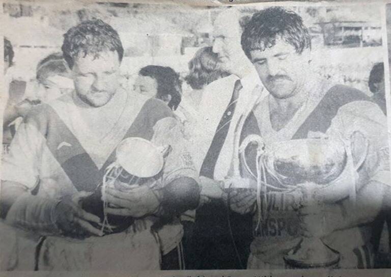 BLAST FROM THE PAST: Johnny Burke and Bryan Milthorpe showing off their Group 6 premiership cup and club championship cup for 1984. Photo supplied by Andrew Hicks.