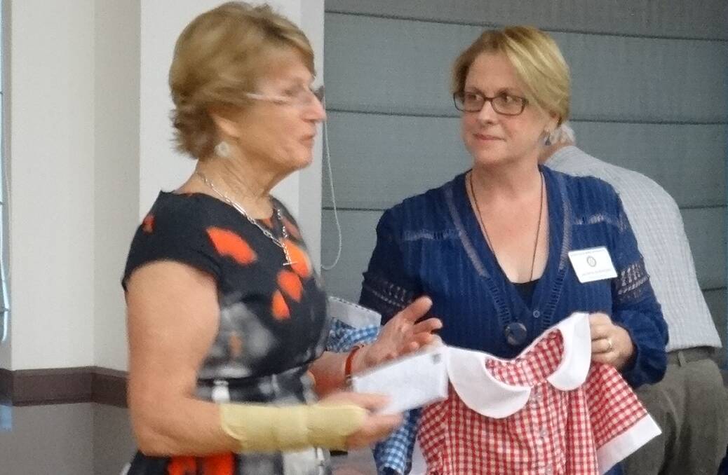 Jacinta Sheridan (right) and Trish Rheinberger with one of the many uniforms to be donated to children in Vanuatu.