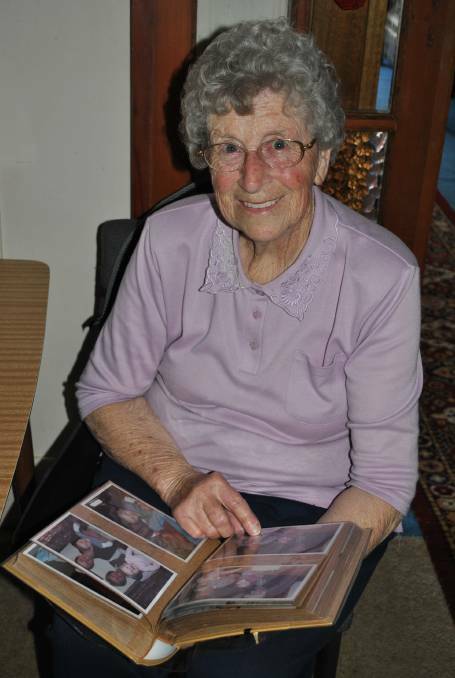 Jone Armstrong takes a closer look at an album of pictures of the families supported by Rainbow of the Southern Highlands. Photo: Jackie Meyers
