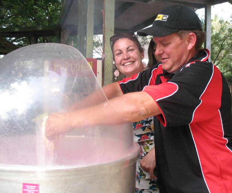 A HELPING HAND: Lynda Rough and Geoff Kull at the fairy floss stall at Moss Vale Public School's fete last year. Photo supplied