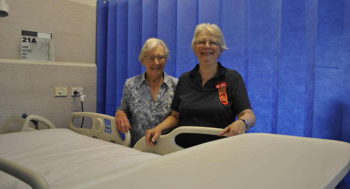 Bowral Hospital Auxiliary members Peg Harvey and Wendy Pedley with one of 
the new beds and tables at Bowral Hospital. 