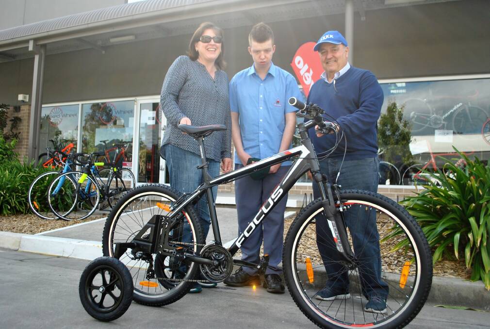 BRAND NEW BIKE: Cooper receiving his new bike with mum Naomi Ringholt and Kollege of Knowledge Kommittee for Kids president Tony Springett at the Fixed Wheel in Bowral.