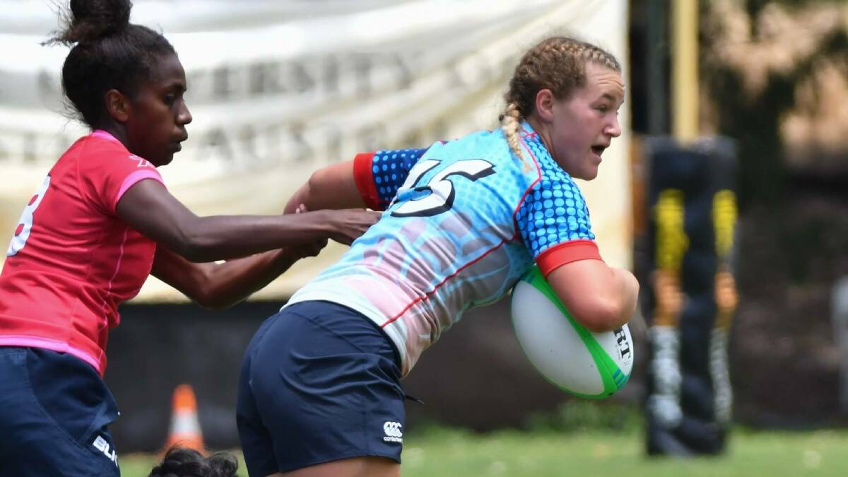 RUGBY 7s: Arabella McKenzie looks to offload the ball at the under-18 national 7s youth championships. Photo: Andrew Mayberry Photography. 
