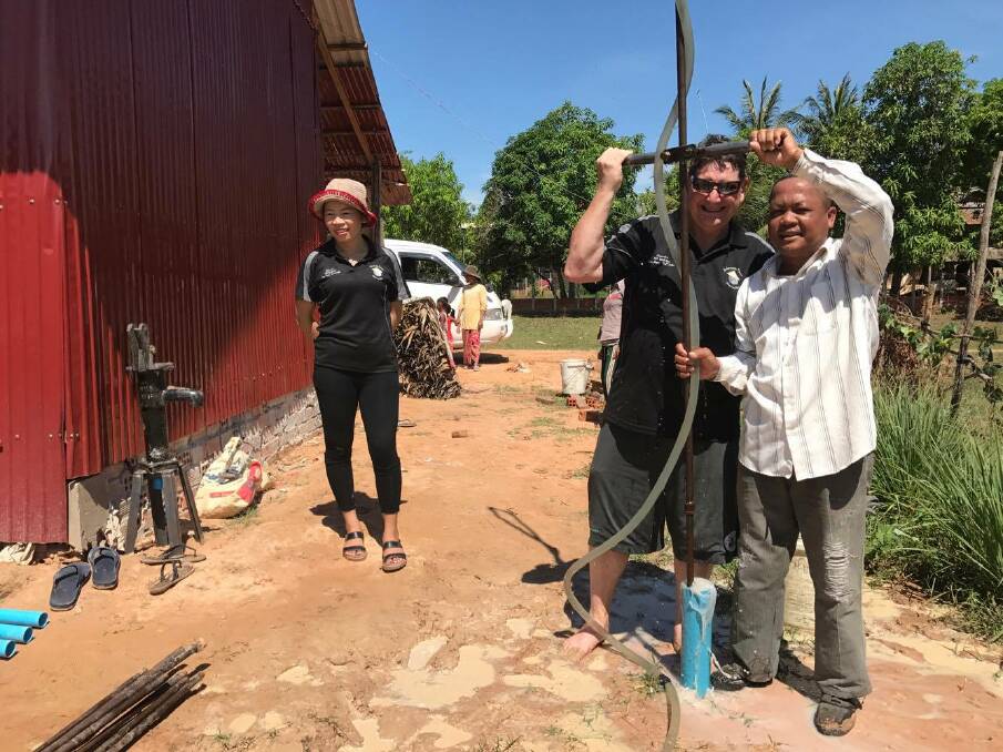 WATER FOR ALL: Craig Hawkins with Virak after a successful build of  a water pump in Cambodia. Photo: supplied. 