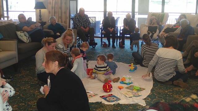 Mums and bubs playing while residents watch on at Bowral House. 