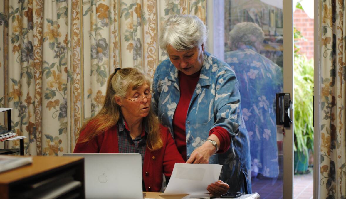 ARCHIVAL PROCESS: Helen Erskine and Leonie Knapman look over old newspaper articles at Ms Knapman's home office. Photo: Madeline Crittenden.