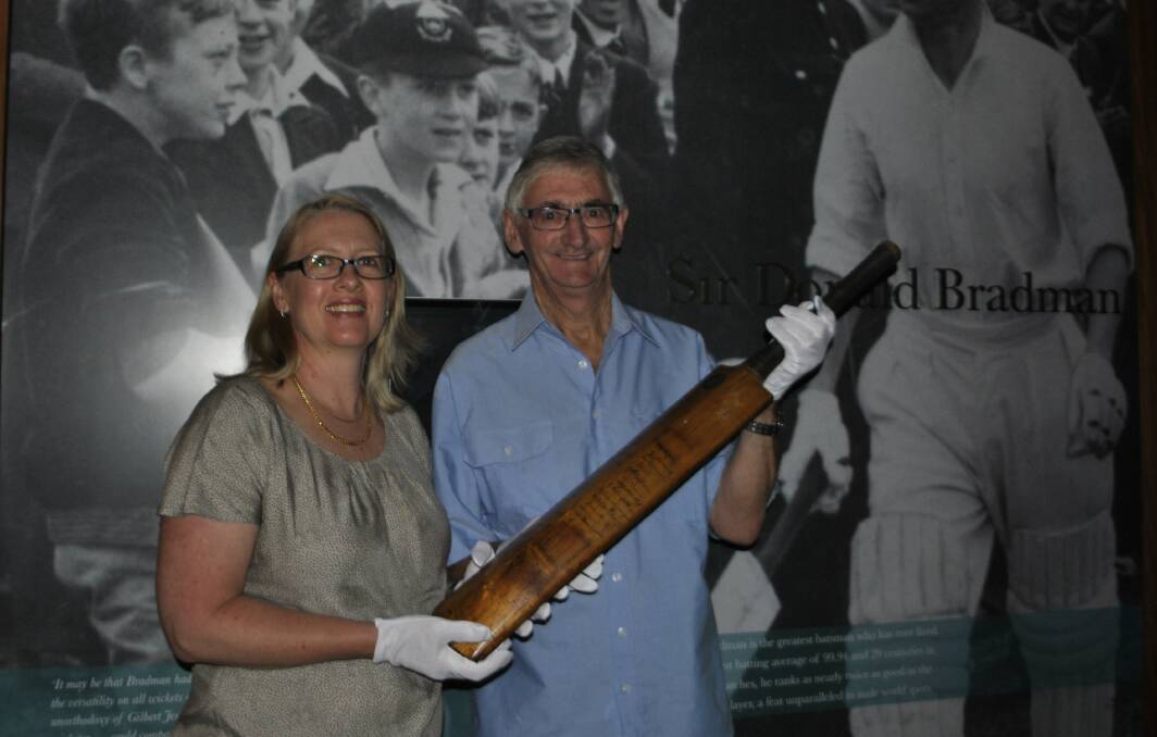 Harold Larwood's granddaughter Karen Khoury, and former bat owner John Clancey holding the bat signed by England and Australia during the 1932/33 Bodyline series. Photo: Madeline Crittenden. 