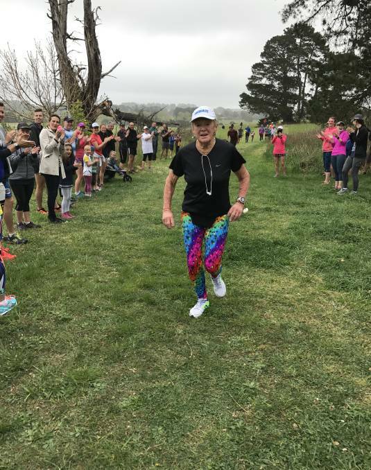ACCOMPLISHED: About 100 people formed a guard of honour for runner Norma Wallett, who finished her 100th parkrun in Bowral on Saturday, October 14. Photo: Barry Smith