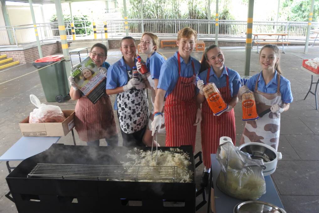 Proud to help: Cindy Pryma with student volunteers Grace (Year 10), Rhiannon (Year 10), Damon (Year 11), Kelsey (Year 11) and Natarsha (Year 7) cooking up a storm for the Closing the Gap barbecue. Photo: Claire Fenwicke