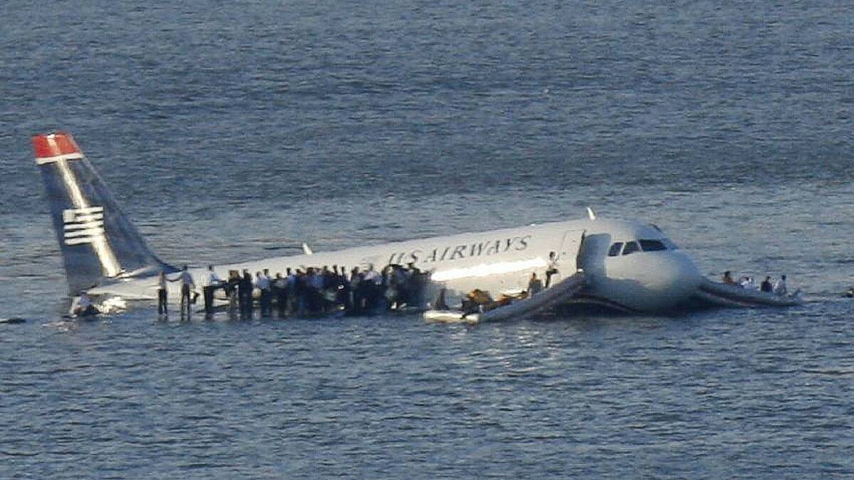 Passengers stand on the wings of a U.S. Airways plane as a ferry pulls up to it after it landed in the Hudson River in New York, January 15, 2009. Photo: REUTERS, FDC