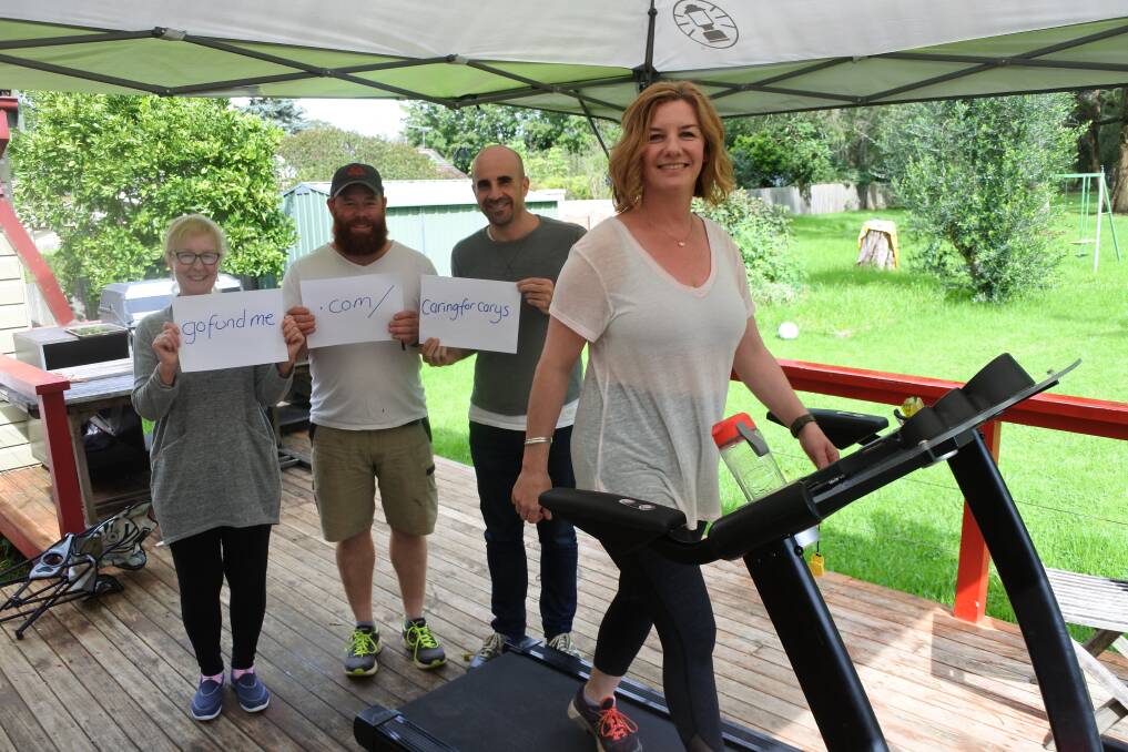 Tracy Proud on the treadmill with support crew and participants, her mother Sue Bray, husband Joe Proud and friend Mick Garnett. Photo: Claire Fenwicke