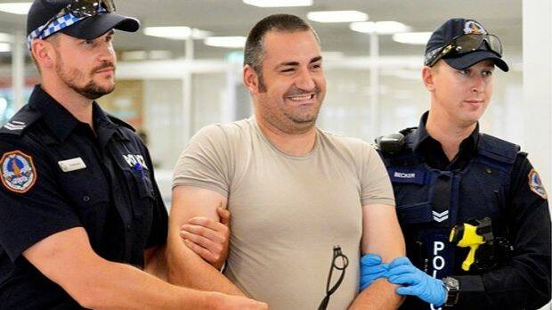 Aniello Vinciguerra is walked through Darwin Airport by two police officers after his arrest in December, 2014. Photo: Supplied
