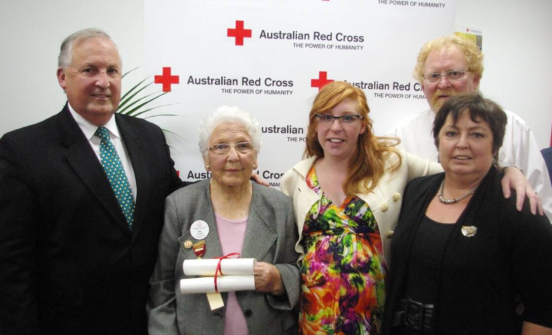 Iris Clout receiving the Australian Red Cross Laurel Wreath supported by her family; son Terry Clout, Iris Clout, granddaughter Cassandra Nguyen, son-in-law Brian Dickson, daughter Catherine Dickson.