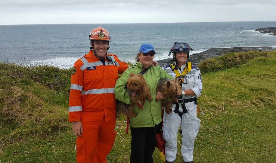 RELIEF: Rescuers pose with two dogs retrieved from a cliff face at Gerroa and returned to their grateful owner. Picture: Illawarra Police Rescue Squad 