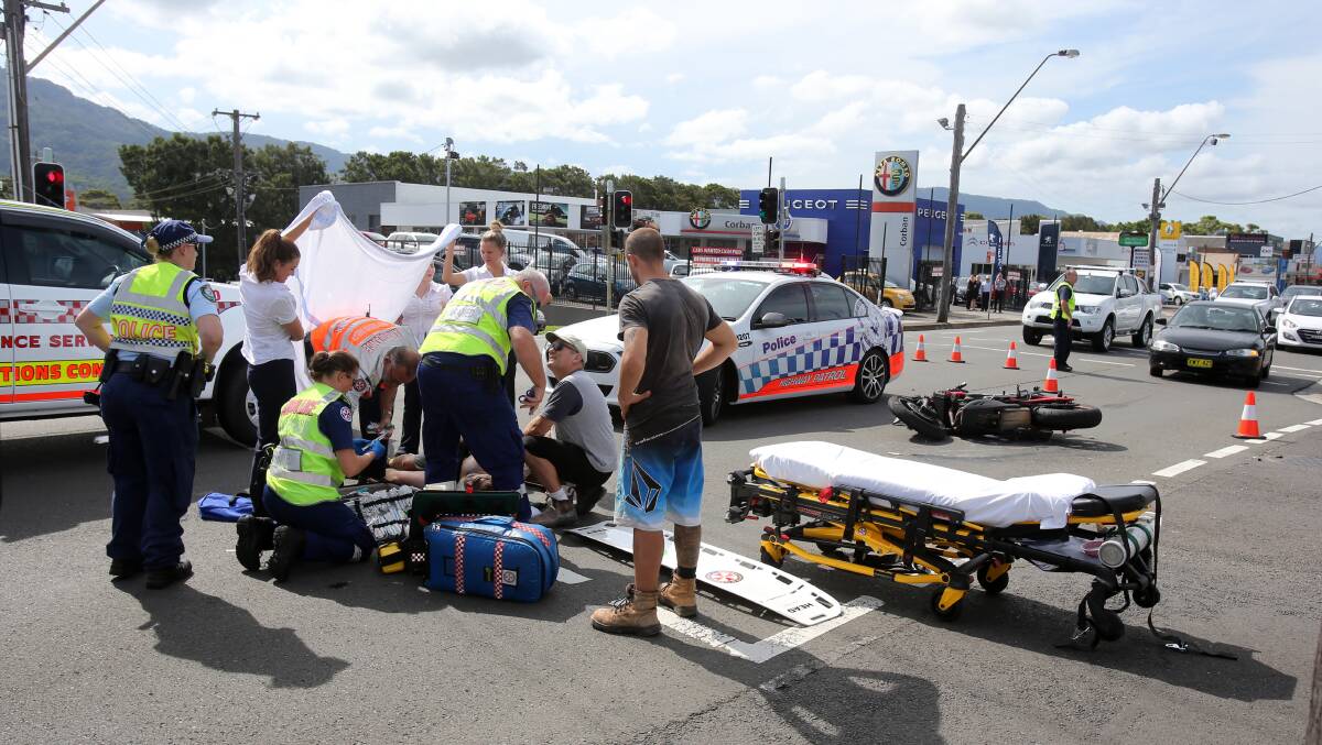 Bystanders provide shade for the injured man as paramedics come to his aid. Picture: Robert Peet