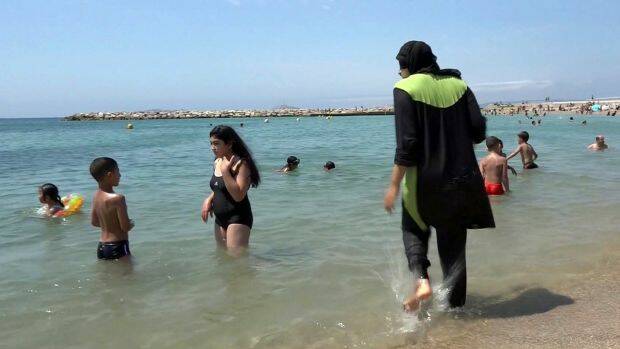 Nissrine Samali, 20, gets into the sea fully clothed in Marseille, southern France. The Cote d'Azur city of Cannes has banned burkinis. Photo: AP
