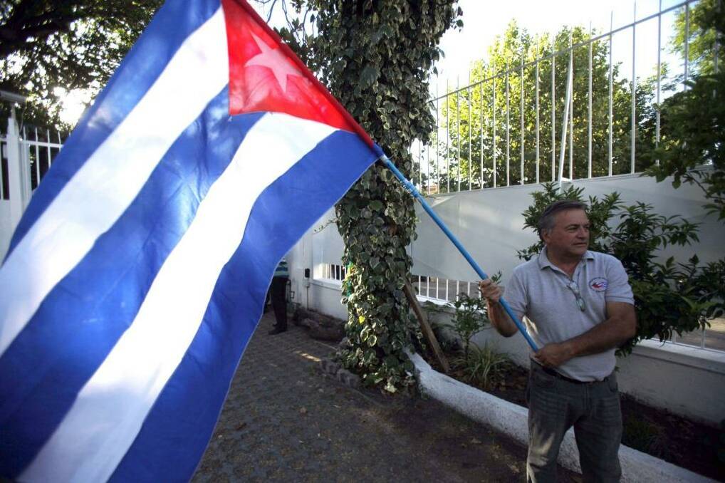 Reason to celebrate: A man waves a Cuban flag while celebrating the restoration of diplomatic relations after a half-century of Cold War acrimony between the island nation and the US.