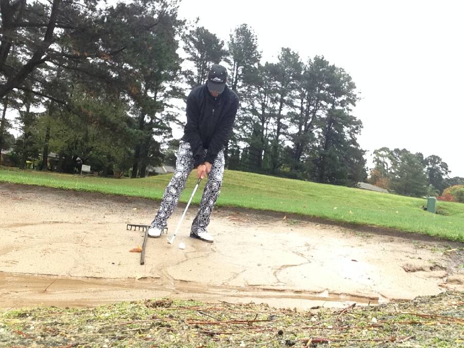 Tony White practises his swing of the club from the bunker.            Photo supplied