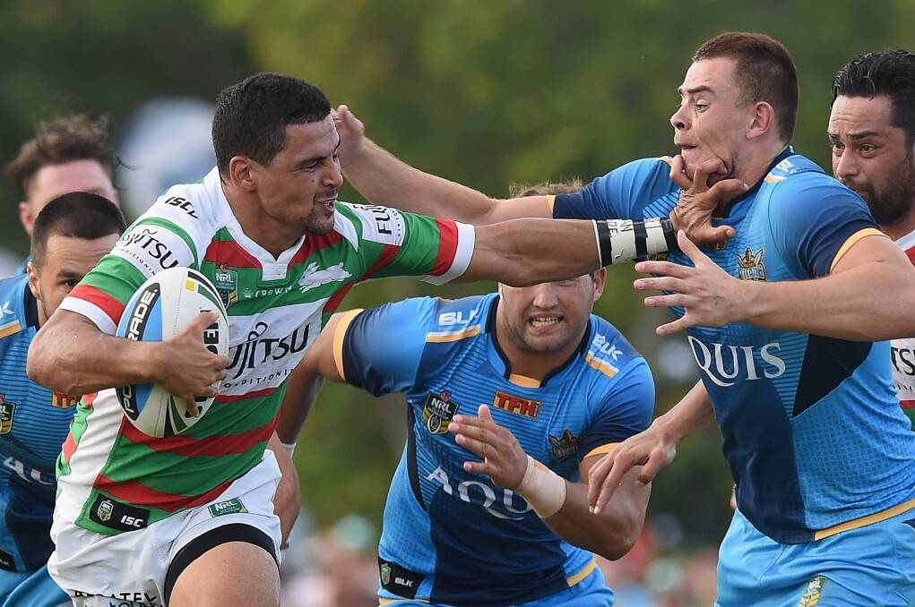 Cody Walker (with ball) palms off a couple of opponents while representing the South Sydney Rabbitohs. Photo: FDC