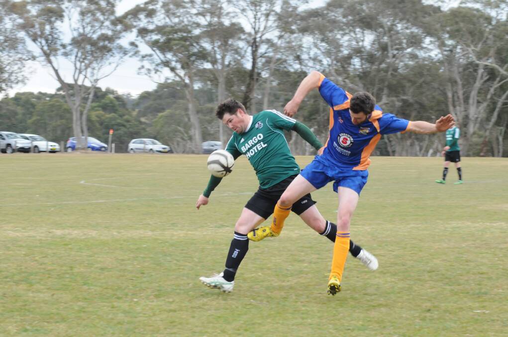 Pat Haynes only has eyes for the ball as a Bundanoon defender comes charging in. Photo by?Lauren Strode