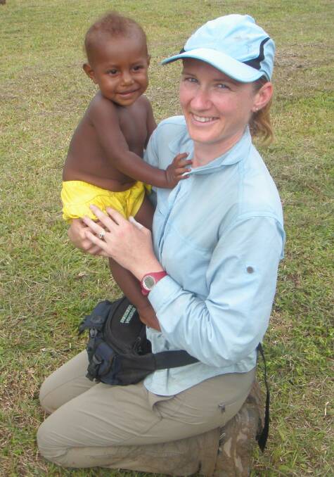 Fiona Foster with a baby in Menari, a native community on the Kokoda Track. Photo supplied