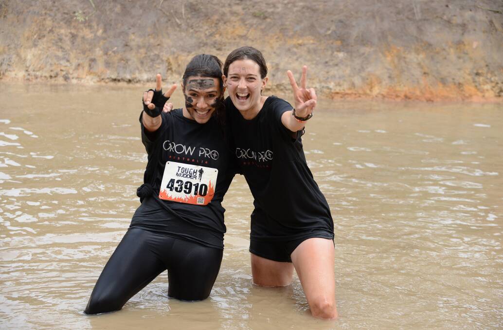 Marta Gil and Lidon Llansok manage a big smile after completing the Tough Mudder course at Wingello. Photo by Roy Truscott