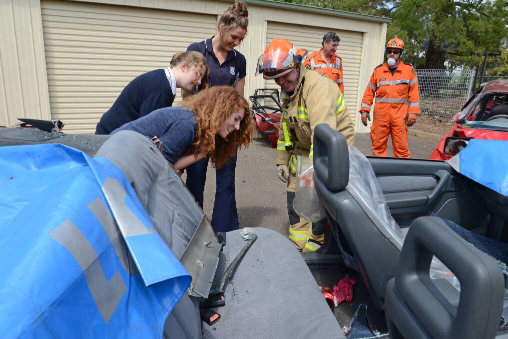 Students Caitlin Stephens, Victoria Morris and Simone Fedele can t believe what firefighter John Arnot shows them in the car: a baby's dummy.
