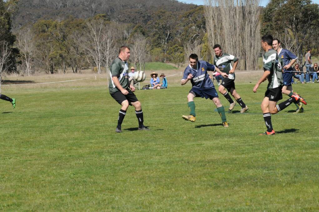 Dave Winn who scored a hat-trick in Mittagong's win passes to a teammate.  
	Photo by Lauren Strode