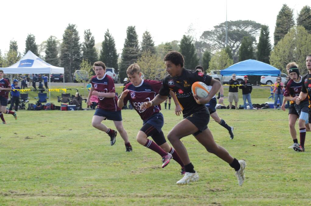 Young Bowral player Babucarr McKern makes a break during the Rugby 7s tournament.         Photo by Lauren Strode