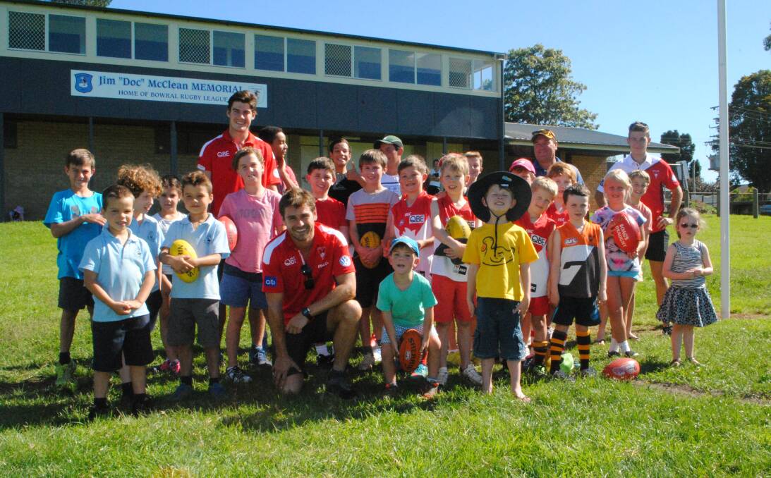 Sydney Swans representatives Nick Smith (front), George Hewett and Kaleb Riddington with Highlands juniors and local fans at Loseby Park. Photo by Josh Bartlett