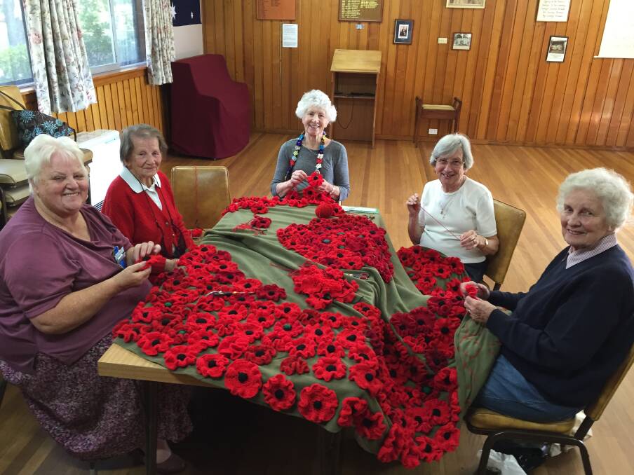 Country Women's Association members (L-R) Carol Nolan, Mary Orford, Rita Gilroy, Wendy Davis, and Beverley Worner stitching 800 crocheted and knitted poppies onto a cover for the Mittagong Cenotaph. 	Picture: Ainsleigh Sheridan