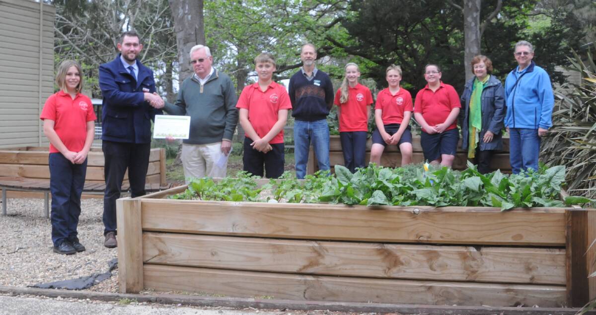 Exeter Public School principal Andrew Barnes presents Highlands Garden Society president Ray Bradley with a certificate of appreciation for the $3500 donation along with student leaders Charlotte Gray, Clayton de Leeuw, Hayley Brown, Sean Quigley and Joel Douglas and garden society committee members Bob Bailey, Noelene Bailey and Nick Marshall. Photo by Lauren Strode