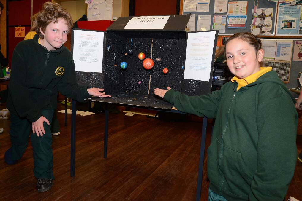Year 5 students Edwin Coward and Braelyn Horvath with their model of the solar system. 
	Photo by Roy Truscott