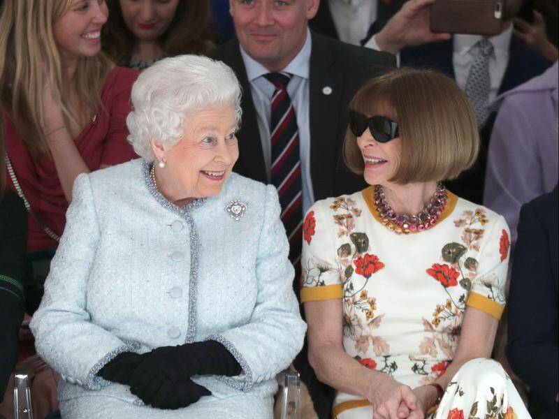 Queen Elizabeth sits next to Anna Wintour on the front row of a catwalk at London fashion week.