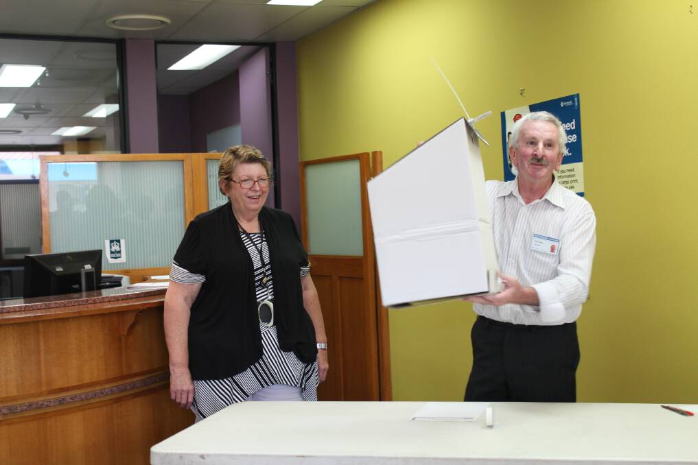 Ross Baker from the NSW Electoral Commission shakes the ballot box.  
		Photo by Megan Drapalski