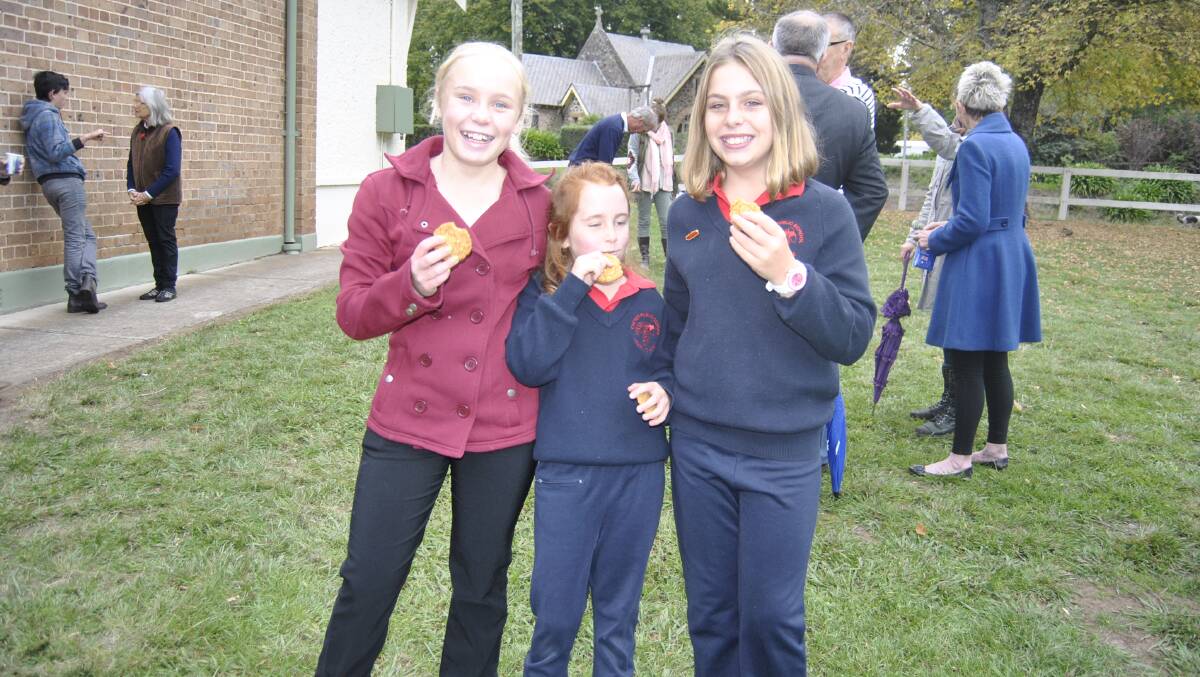 Daisy Schaefer (12), Tasman Hawke (7) and Charlotte Gray (12) enjoy some Anzac cookies at Exeter. Photo by Dominica Sanda
