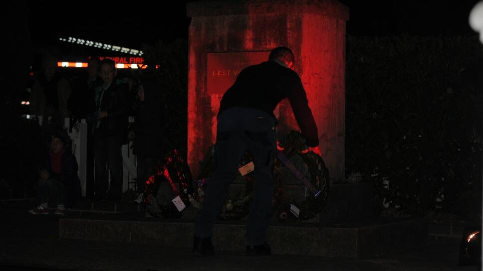 A representative from the Rural Fire Service lays a wreath on the Berrima Cenotaph for the dawn service. 