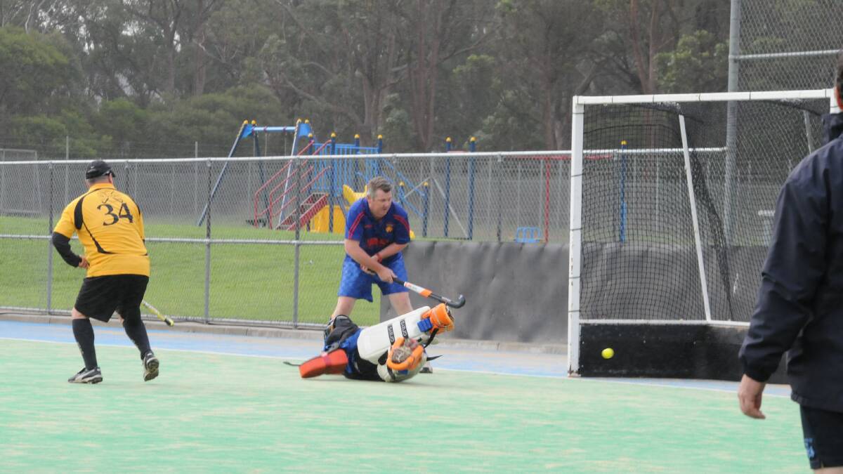 Pat Cleary sneaks the ball past Robertson goalkeeper Tom Isaksoon to score as the rain comes down during Burrawang's win over Robertson. Photo by Lauren Strode
