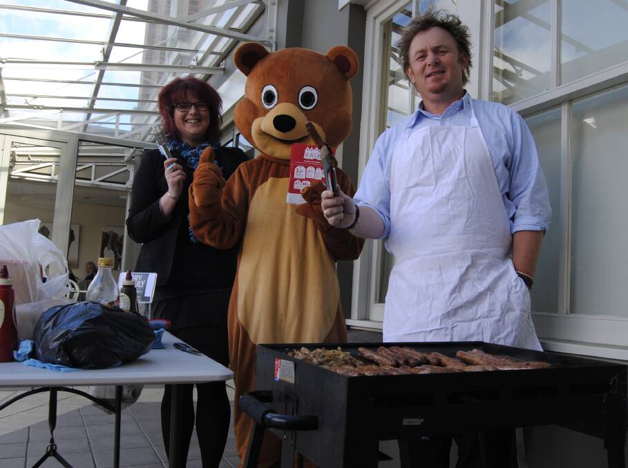 BDCU team leader Erin Mills, member service officer Maddison Feld, dressed as BDCU Bear, and business development manager Ross Webb man the barbecue to promote the upcoming BDCU sale day. Photo by Josh Bartlett
