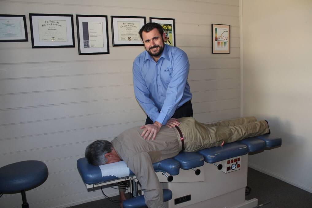 Chiropractor Pete Burt adjusts Frank De Silva. Photo by Megan Drapalski