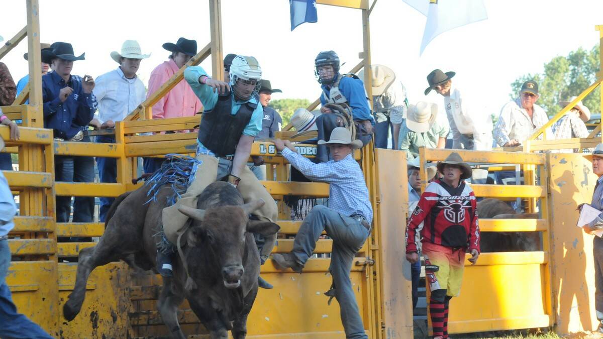 Highlands novice bull rider Harry Ash does his best to try and stay on the bull at the Moss Vale Rodeo. 