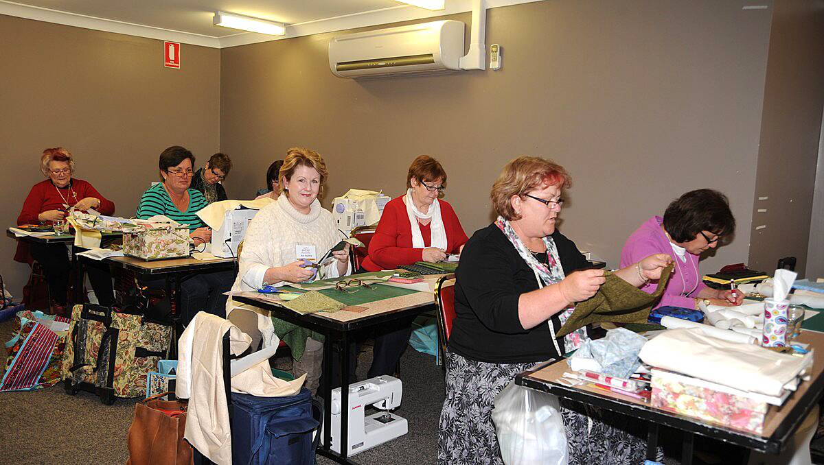 The quilting class cutting the material to size.