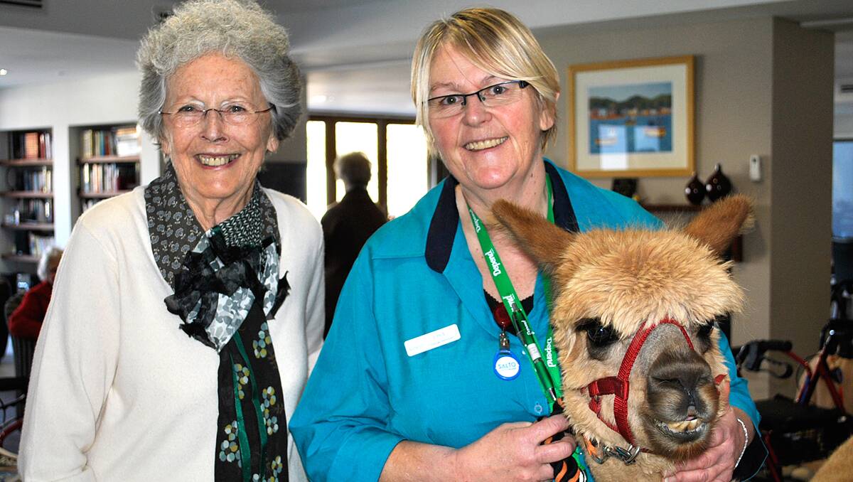 Jackie Wilscher and personal carer Lisa Buttigiek with Honeycomb the alpaca. Photo by Emma Biscoe