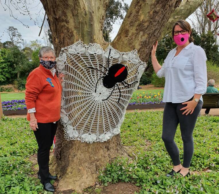 Moss Vale Evening CWA President Jennifer Bowe stands with crafter Lesley Tetley who created one of the spiders displayed in the trees. Photo: Moss Vale Evening CWA Facebook