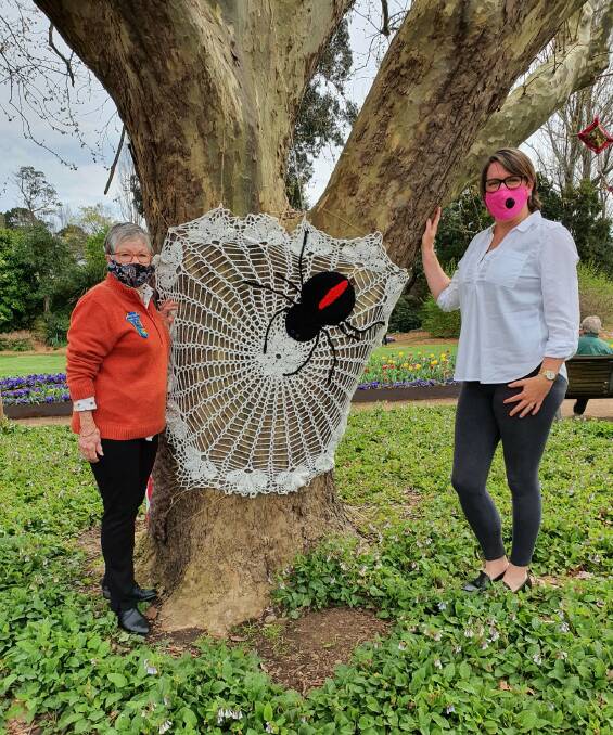 Moss Vale Evening CWA President Jennifer Bowe stands with crafter Lesley Tetley who created one of the spiders displayed in the trees. Photo: Moss Vale Evening CWA Facebook 