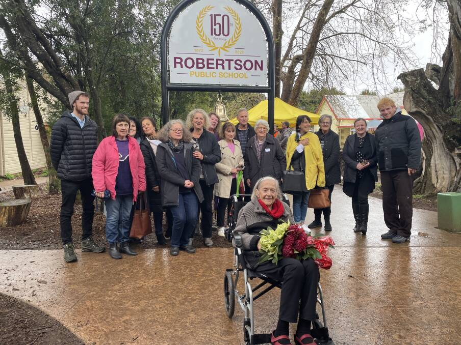 Robertson Public School's oldest former student Gladys Fisk (front with the bouquet of flowers) stood with her family in front of the commemorative bell which marks 150 years since the school opened. Picture by Briannah Devlin. 