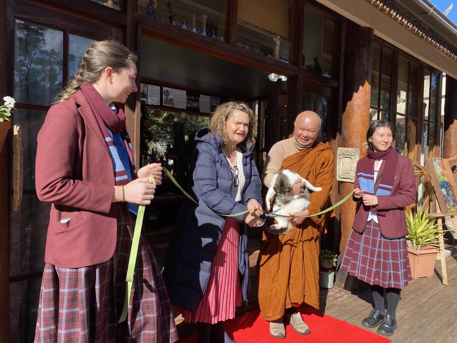 Goulburn MP opened the exhibition with Chevalier college students and monk Phra Mana, with the monastery's furry "manager". Photo: Briannah Devlin. 